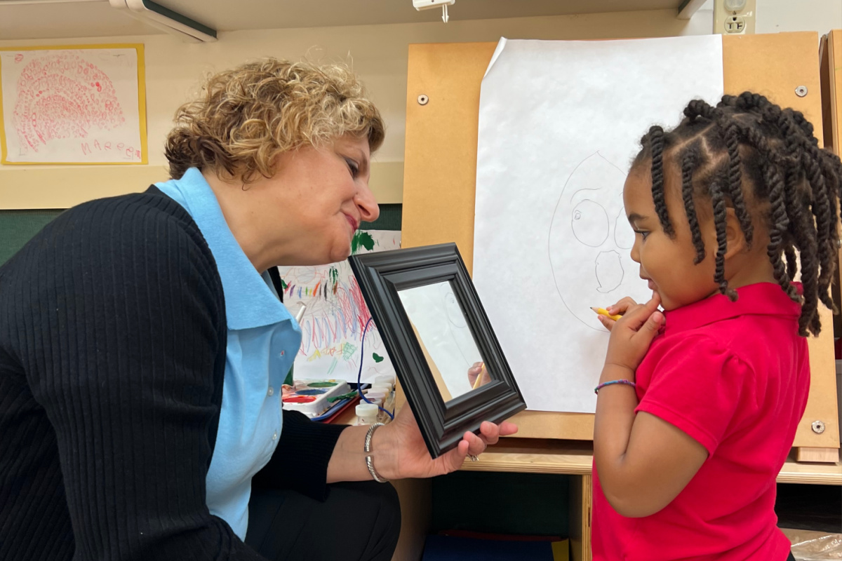 Teacher and preschool child explore diversity